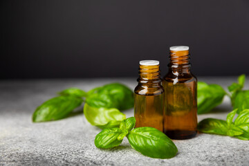 Basil essential oil on a textured wooden background. Basil essential oil and fresh leaves. Aromatherapy. Aroma oil. Medical herbs. Alternative medicine. Place for text. Copy space.