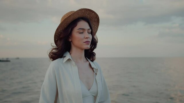 Emotionless woman tanding near sea and looking into horizon