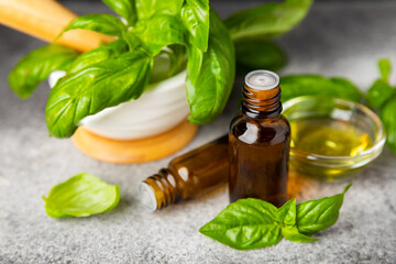 Basil essential oil on a textured wooden background. Basil essential oil and fresh leaves. Aromatherapy. Aroma oil. Medical herbs. Alternative medicine. Place for text. Copy space.