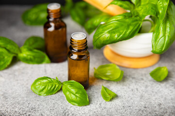 Basil essential oil on a textured wooden background. Basil essential oil and fresh leaves. Aromatherapy. Aroma oil. Medical herbs. Alternative medicine. Place for text. Copy space.