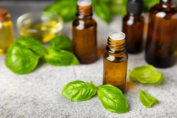 Basil essential oil on a textured wooden background. Basil essential oil and fresh leaves. Aromatherapy. Aroma oil. Medical herbs. Alternative medicine. Place for text. Copy space.