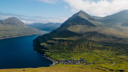 Funningur village, Faroe Islands. Sunny day in summer. Amazing nature in Faroe Islands. Eysturoy Island. Gonguturur or Hvithamar Trailhead. Faroese fjord and summits