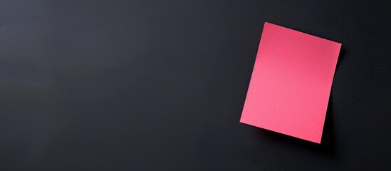 Copy space image with a pink note set against a black gradient backdrop
