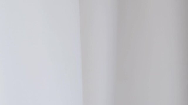White fabric background waving gently, creating a soft, airy, and elegant tulle effect