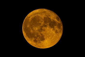 Full Buck moon glowing orange rising over Ottawa, Ontario, Canada, July 21, 2024 against a black...