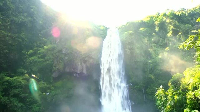 Joyful young African American man standing with arms wide open, enjoying nature near a waterfall. Outdoor summer getaway, tropical vacation, and adventure travel experience, embracing freedom and rela