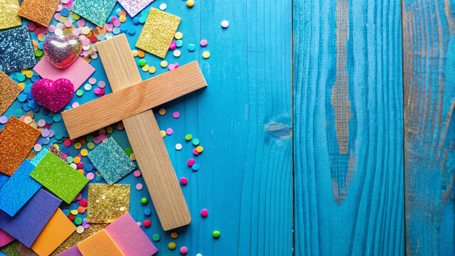 Colorful Christian-themed craft supplies scattered around a wooden cross, including stickers, glitter, and construction paper, on a bright blue background with ample space for text.