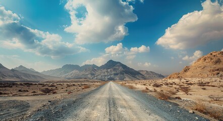 Naklejka premium Dirt Road in Dubai's Hajar Mountains: A Captivating View of Middle East Beauty