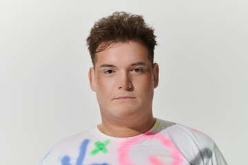 Brown-haired youth stares at camera in a colorful shirt
