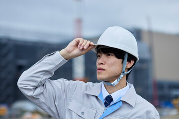 ヘルメットを被る建設現場のビジネスマン