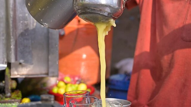 Vendor pouring sugar cane into glass, Man make eco sugarcane juice. Rural guy produce sweet rum drink. Street vendor chop up raw cane fiber. Local maker sell sugar sap. Grinder mill crush sugarcanes