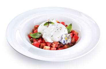 Burrata cheese with tomatoes, edible flower and basil, on a plate on a white background.