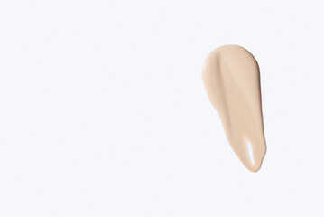 Liquid foundation smudge on white background. Beauty skincare texture swipe swatch. Cosmetic makeup...
