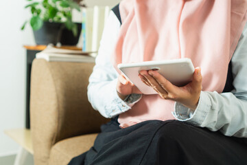 Close up of business muslim woman using tablet doing  business task on a couch, tax, report, accounting, statistics, and analytical research