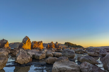 Fototapeta premium 夕日が照らす海岸の橋杭岩