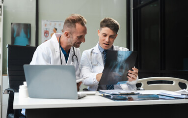Fototapeta premium Medical team working on digital tablet healthcare doctor technology tablet using x-ray film analyzed the results of medical reports.