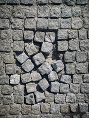 Broken paving slabs made of natural granite are laid out with a pattern. Decorative street background. Sidewalk. Modern road surface.