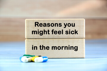 reasons you might feel sick in the morning wording  or text on wooden block with brown wooden background with pills.Copy space and business concept.