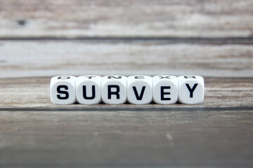 survey wording  or text on white dice with black wooden background.Copy space and business concept.