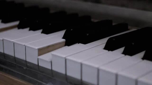 Piano or Grand Piano Playing Itself. Performing a musical composition on a piano that plays by itself. Self-Playing. White, black piano keys press independently without human intervention. Close up.