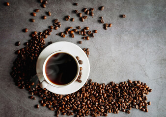 Naklejka premium Overhead view of black coffee cup aromatic . Coffee cup and coffee beans on gray background