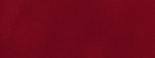 Dark red matte background of suede fabric, closeup. Velvet texture of wine seamless textile, macro.