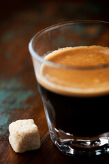 Coffee in glass cup on dark background. Close up.