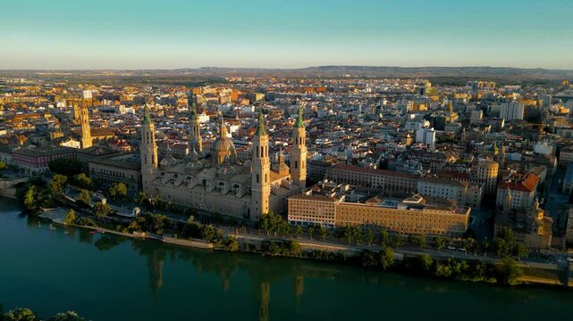 Spectacular orange sunset over ZARAGOZA city. River Ebro and Cathedral of Zaragoza. Drone going background. Panoramic aerial view of all city. Medieval and historic city. Famous travel destination.