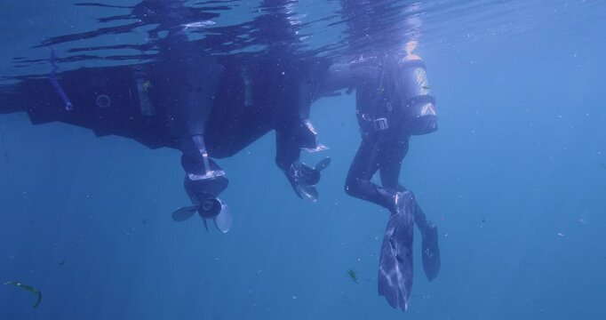 Scuba diver cleaning transom of boat.