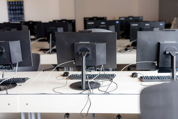 Monitors and keyboard in an empty computer lab at a secondary school.