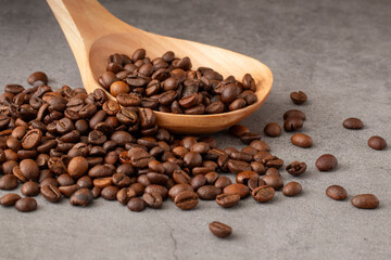 Mountain of coffee beans with wooden spoon to collect them