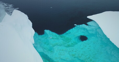 Natural beauty of glacier melting in Antarctica. Iceberg with blue water lake inside. Cold South...