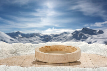 Wooden snow covered table top with wooden tray bowl for products. Copy space for montage objects...