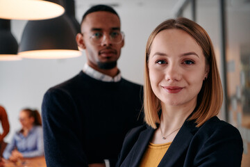 Dynamic Leadership Duo: Blonde Director and Young African American Entrepreneur in Office Setting.