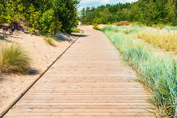 A walk along the beach wooden path along the sea in summer time.