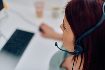 Friendly Call Center Agent Answering Incoming Calls with Headset Providing Remote Customer Service.