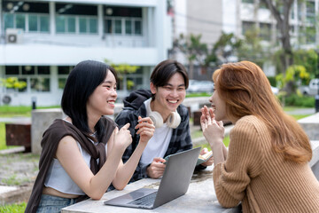 Three young people are sitting at a table, laughing and smiling