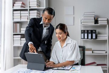 Fototapeta premium A man and a woman are working together on a laptop