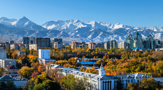 Aerial view of the central part of the Kazakh city of Almaty with snow-covered mountains in the background on an autumn morning