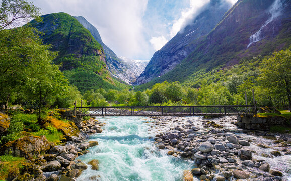 Beautiful mountain river Dalelva (Stryn). Cascade mountain stream with rapids. Briksdal Bridge. Briksdal glacier