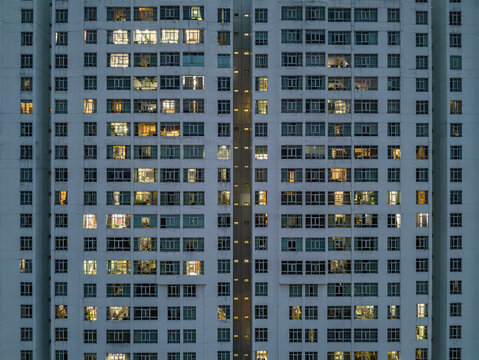 Massive Hi-Rise Residential Building Facade from Aerial View  Large housing development of several towers shot revealing the city at night illuminated.
