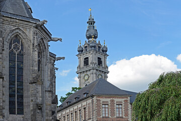 Belfry towerd and part of the Saint Waltrud church with blue sky and white cloud in Mons, Belgium