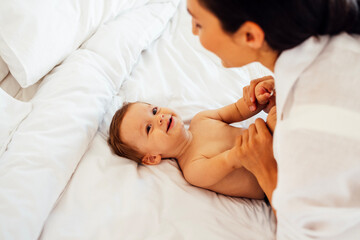 A close-up portrait of a young smiling woman and her sweet baby