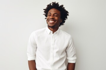 Fototapeta premium Portrait of a satisfied afro-american man in his 20s wearing a classic white shirt isolated on white background
