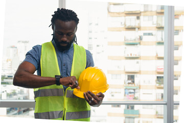 African engineer Man in office checking time to leave