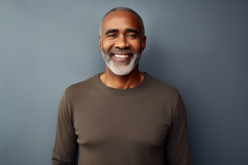 Obraz premium Portrait of a happy afro-american man in his 50s sporting a long-sleeved thermal undershirt isolated in modern minimalist interior