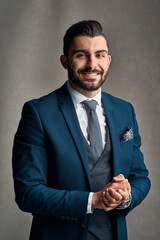 Happy businessman, portrait and suit with fashion for professional career on a gray studio background. Handsome man or young employee with smile or confidence in formal outfit or ready for business