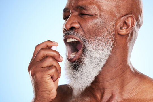Mouth, bottle and black man with spray in studio for oral hygiene, cleaning and fresh breath. Dental, mist and senior person with product on blue background for halitosis, grooming and odor removal