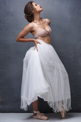 Fototapeta premium Woman, profile and ballet dancer with makeup, beauty or underwear for art, fashion or elegance on a wall background. Attractive female person, young model or performer with confidence, bra and skirt