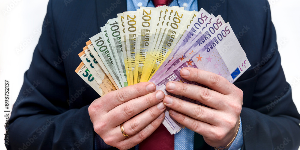 Wall mural business man in suit counting euro money